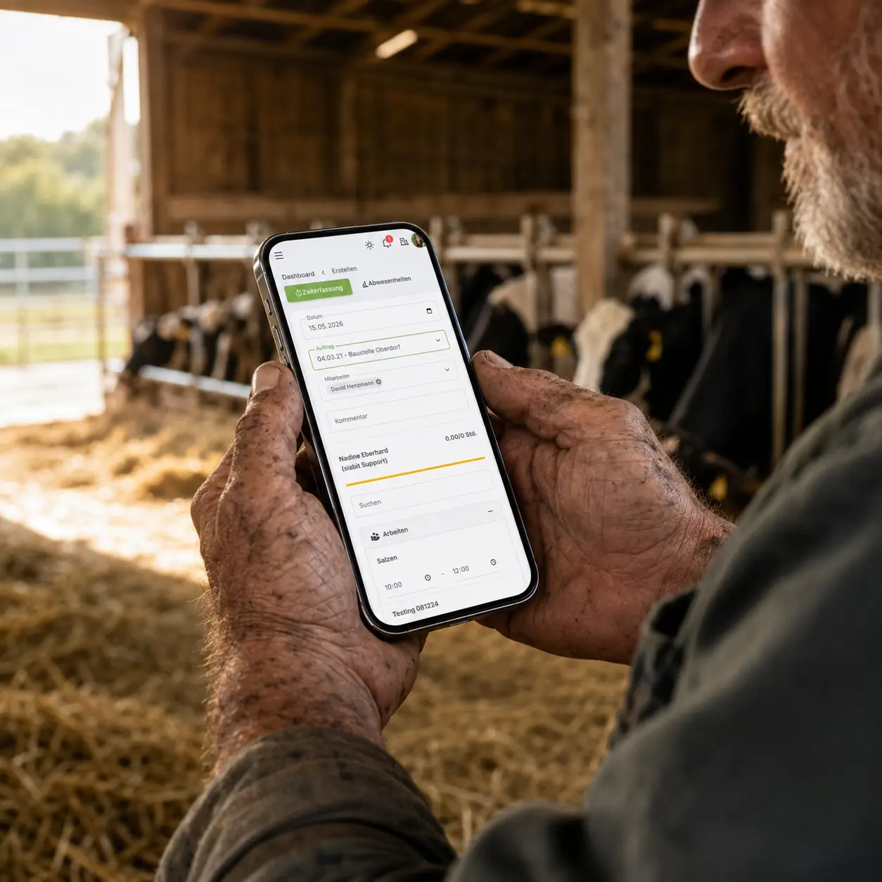Landwirt erfasst Zeit auf dem Smartphone im Stall